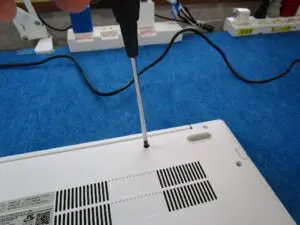 パソコンを裏返して　ネジを外している写真