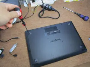 パソコンを裏返して　裏面のネジを外している