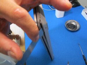 横面から隙間に薄いへらを挿しこんで、フタを外している。